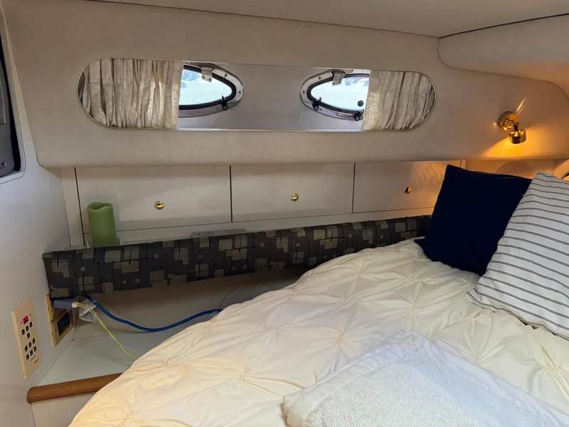 Slide: The Image of Interior cabin of 1997 Sea Ray 450 Sundancer with cozy bed and porthole windows. - 11