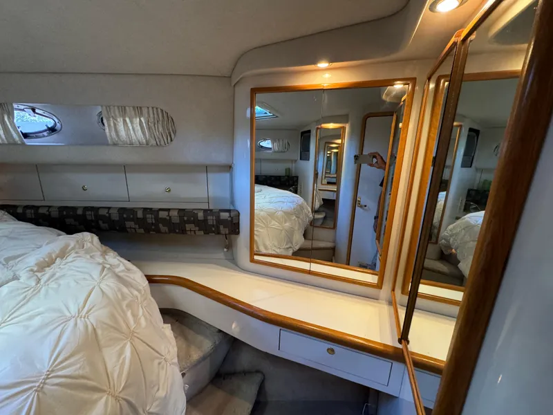 Slide: The Image of Interior of 1997 Sea Ray 450 Sundancer yacht with cozy bedroom and mirrors. - 13