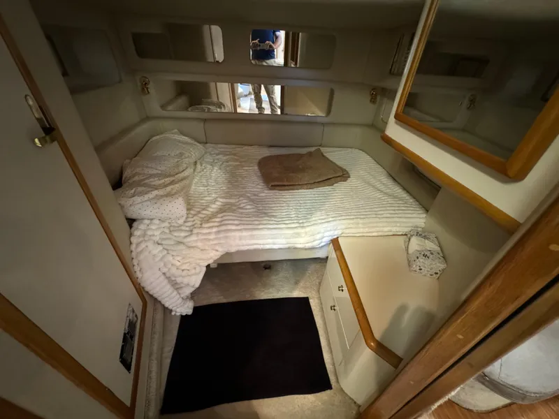 Slide: The Image of Cozy cabin interior of 1997 Sea Ray 450 Sundancer with bed and storage. - 19