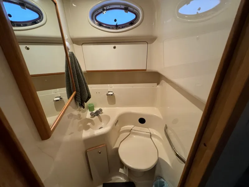 Slide: The Image of Bathroom interior of 1997 Sea Ray 450 Sundancer yacht, featuring compact design and porthole window. - 20