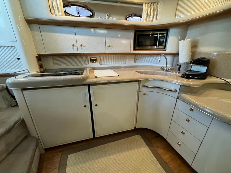 Slide: The Image of 1997 Sea Ray 450 Sundancer yacht kitchen with modern appliances and sleek cabinetry. - 24