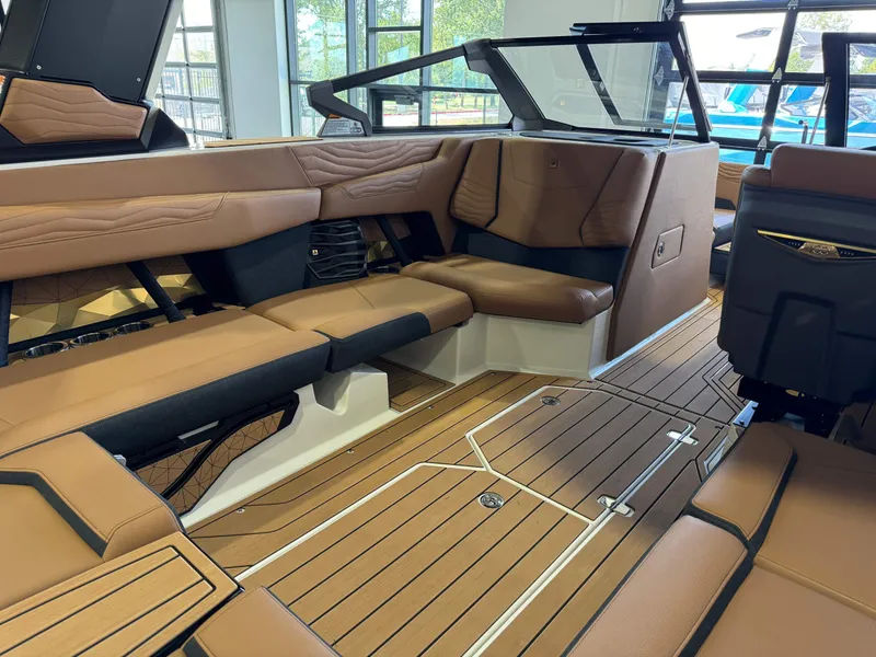 Slide: The Image of 2025 Nautique Super Air Nautique G23 interior with brown leather seating. - 12