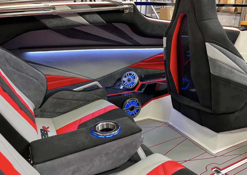 Slide: The Image of 2023 Daves Custom Boats M28R interior with red and gray seating, blue LED cup holders. - 12