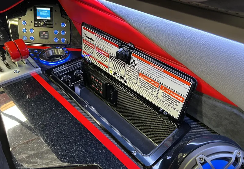 Slide: The Image of 2023 Daves Custom Boats M28R dashboard with controls and warning labels. - 2
