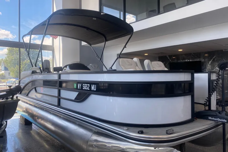 The Image of 2025 Lowe SF 212 W pontoon boat displayed indoors with canopy and seating. - 2