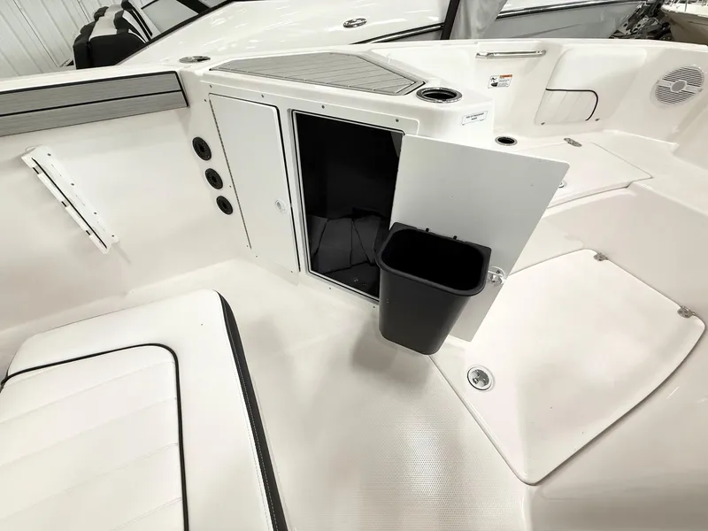 Slide: The Image of 2025 Yamaha Boats 220 FSH Sport interior with storage compartment and trash bin. - 11