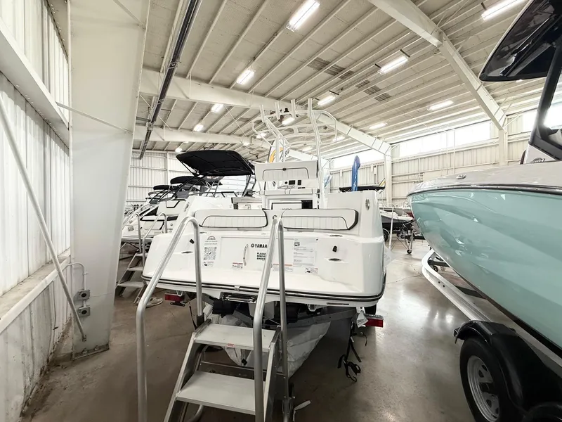 Slide: The Image of 2025 Yamaha Boats 220 FSH Sport in showroom, rear view with ladder access. - 3