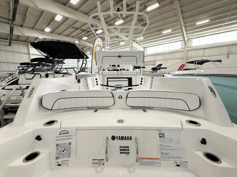 Slide: The Image of 2025 Yamaha Boats 220 FSH Sport interior, showcasing seating and controls in a showroom. - 4