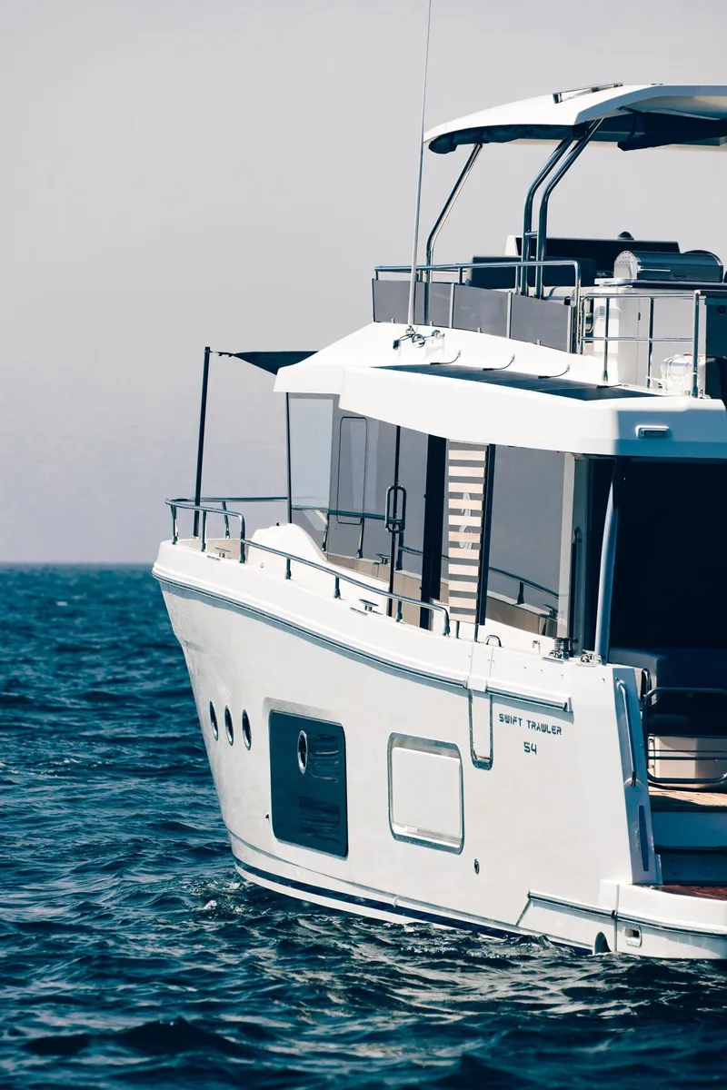 Slide: The Image of 2025 Beneteau Swift Trawler 54 cruising on open water. - 2