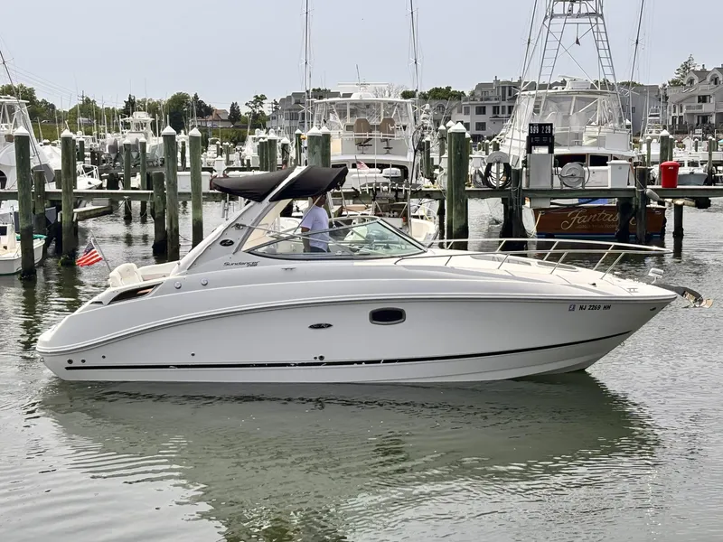 The Image of 2010 Sea Ray 280 Sundancer boat docked in marina, calm water, sunny day. - 1