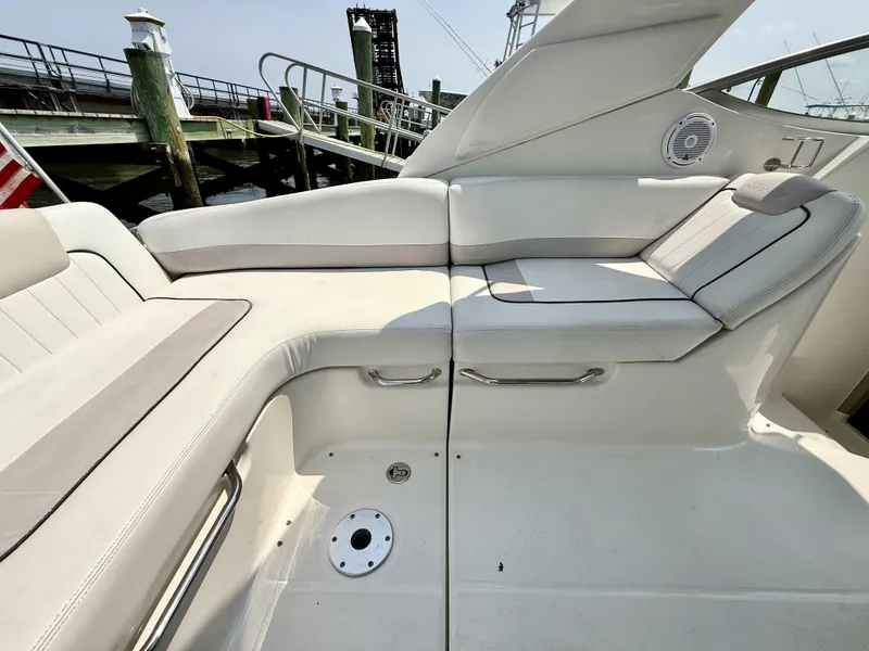 Slide: The Image of 2010 Sea Ray 280 Sundancer boat interior with white seating and dock view. - 5