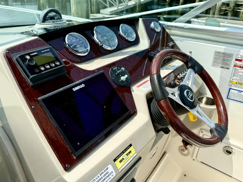 Slide: The Image of Dashboard of 2010 Sea Ray 280 Sundancer with steering wheel and navigation instruments. - 8