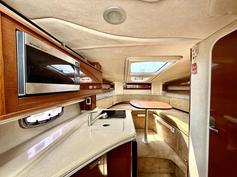 Slide: The Image of Interior of 2010 Sea Ray 280 Sundancer boat with kitchenette and seating area. - 9