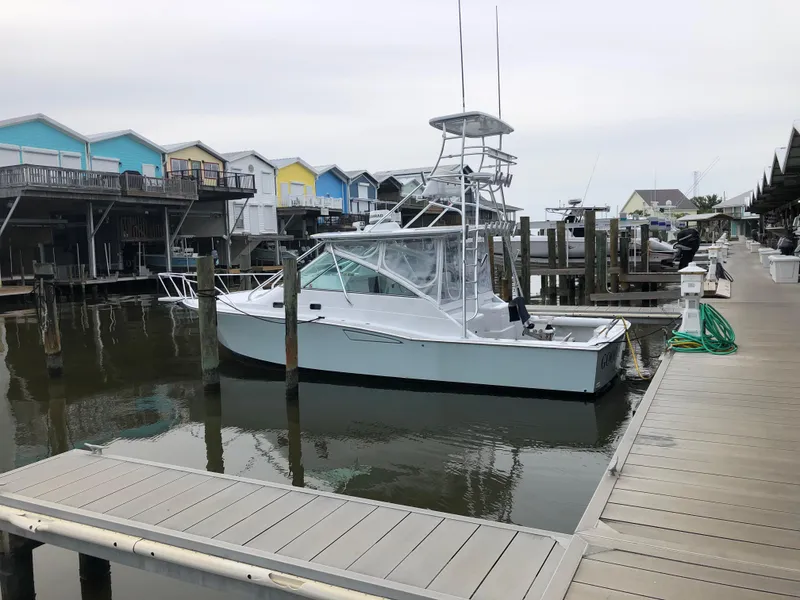 Slide: The Image of 1995 Cabo 35 Express boat docked near colorful waterfront houses. - 1