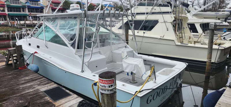 Slide: The Image of 1995 Cabo 35 Express boat docked at marina, featuring sleek design and spacious deck. - 14