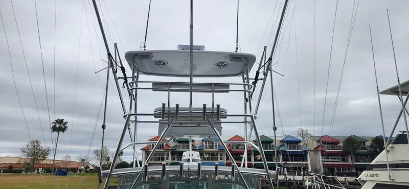 Slide: The Image of 1995 Cabo 35 Express boat with fishing tower, docked near colorful waterfront buildings. - 17
