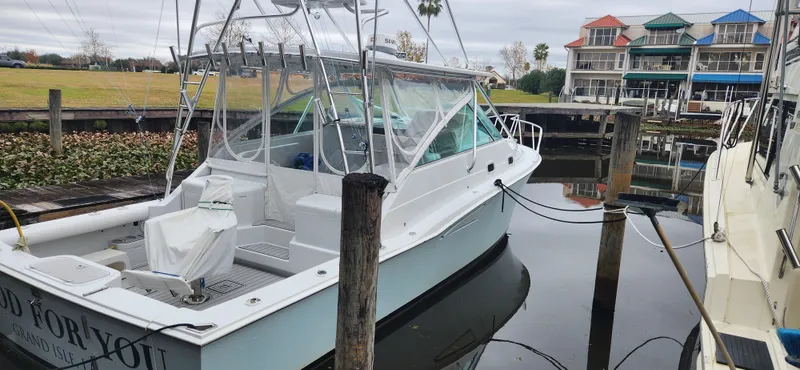 Slide: The Image of 1995 Cabo 35 Express boat docked in a marina with waterfront buildings. - 18
