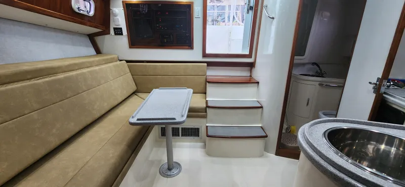 Slide: The Image of Interior of 1995 Cabo 35 Express boat with seating, table, and kitchenette. - 28