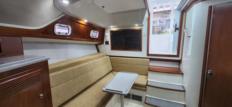 Slide: The Image of 1995 Cabo 35 Express cabin interior with beige seating and wooden accents. - 30