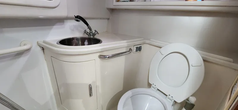 Slide: The Image of Compact bathroom in a 1995 Cabo 35 Express boat with sink and toilet. - 33