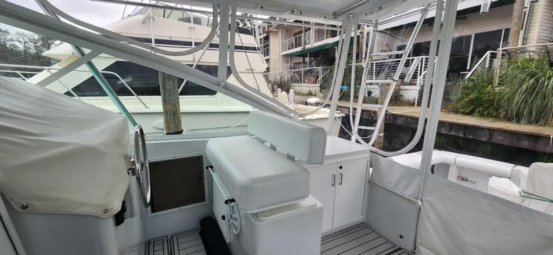 Slide: The Image of 1995 Cabo 35 Express boat interior with seating and helm, docked at marina. - 36