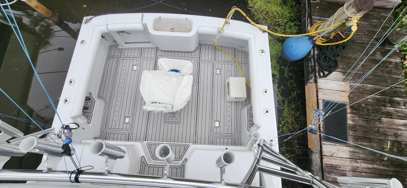 Slide: The Image of 1995 Cabo 35 Express boat deck with fishing rod holders and seating, docked near water. - 49