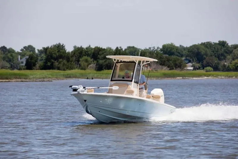Slide: The Image of 2026 Scout 231 XSB boat cruising on a calm river with lush greenery in the background. - 11