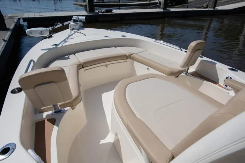 Slide: The Image of 2026 Scout 231 XSB boat interior with beige seating, docked by the water. - 7
