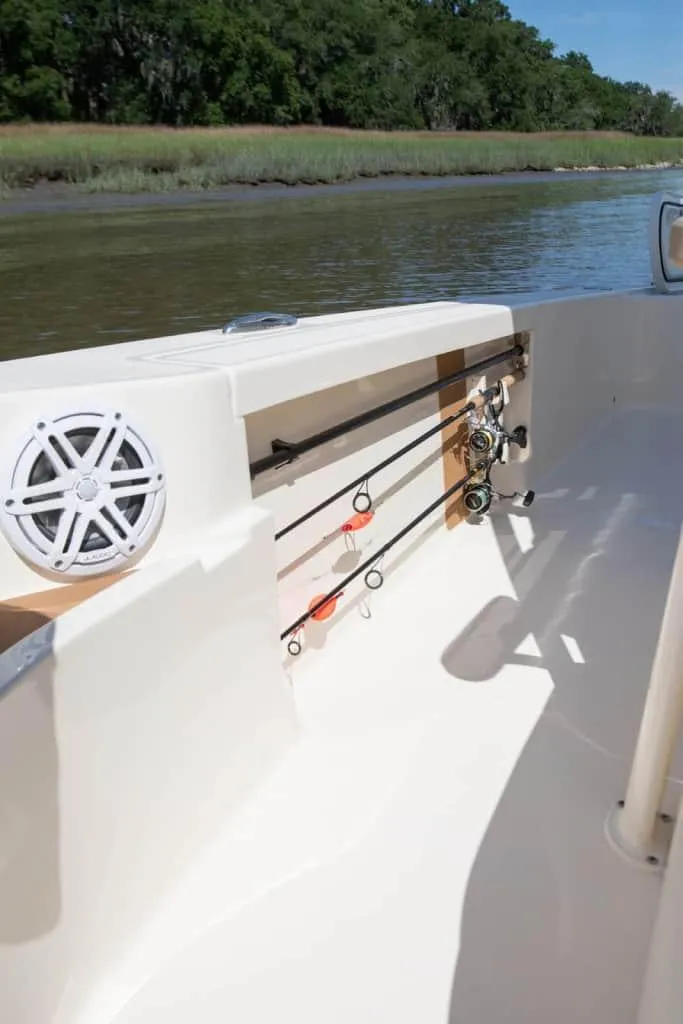 Slide: The Image of 2026 Scout 231 XSB boat interior with fishing rod holders and speaker. - 8