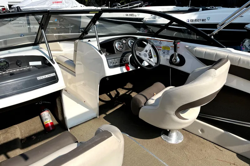 Slide: The Image of 2018 Bayliner 180 Bowrider interior with steering wheel, dashboard, and seating. - 5
