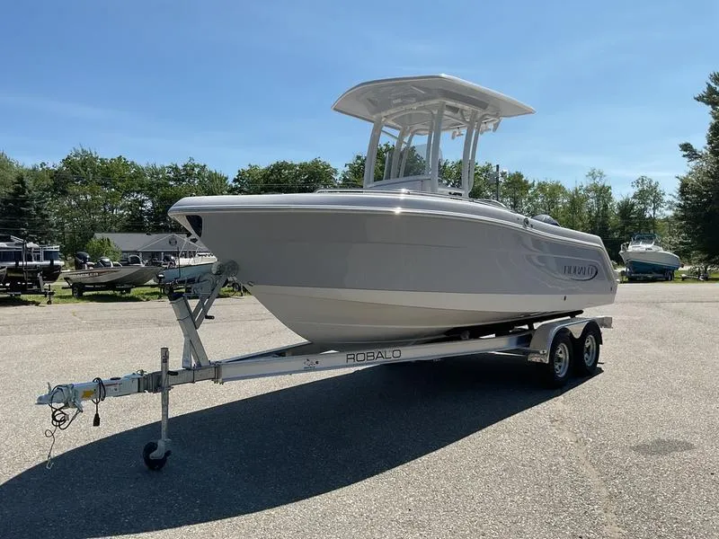 Slide: The Image of 2025 Robalo 222 EX boat on trailer, parked outdoors under clear sky. - 10