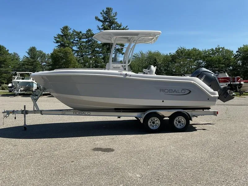 Slide: The Image of 2025 Robalo 222 EX boat on trailer, parked outdoors, clear sky background. - 9