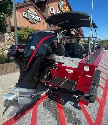 Slide: The Image of 2025 Tracker Targa V-19 Combo boat with outboard motor, parked outside a store. - 3