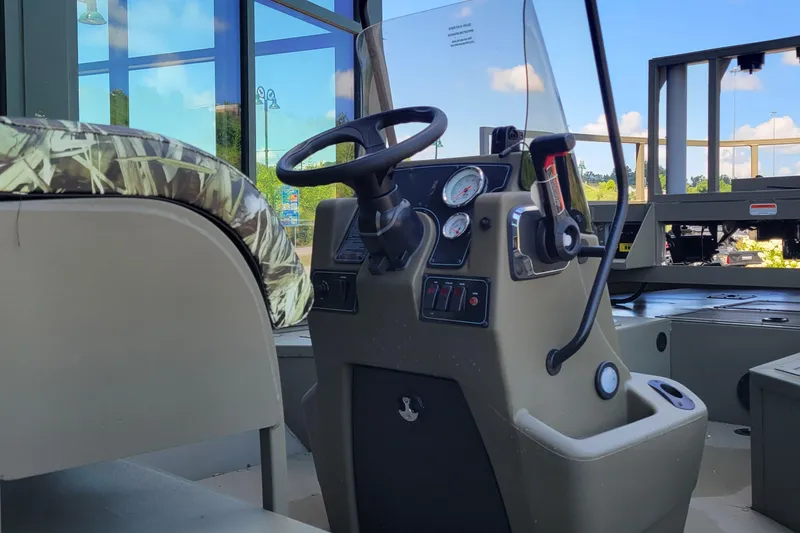 Slide: The Image of 2025 Tracker Grizzly 2072 CC Sportsman boat interior with steering console and camo seat. - 4