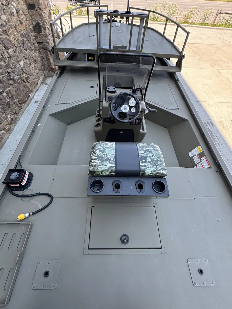 Slide: The Image of 2025 Tracker Grizzly 2072 CC Sportsman boat interior with steering console and seating. - 2