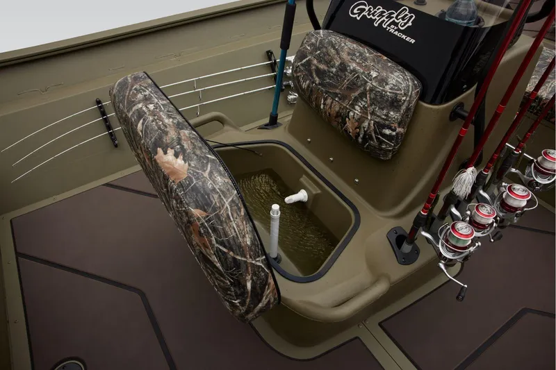 Slide: The Image of 2025 Tracker Grizzly 2072 CC Sportsman boat interior with camo seats and fishing rods. - 3