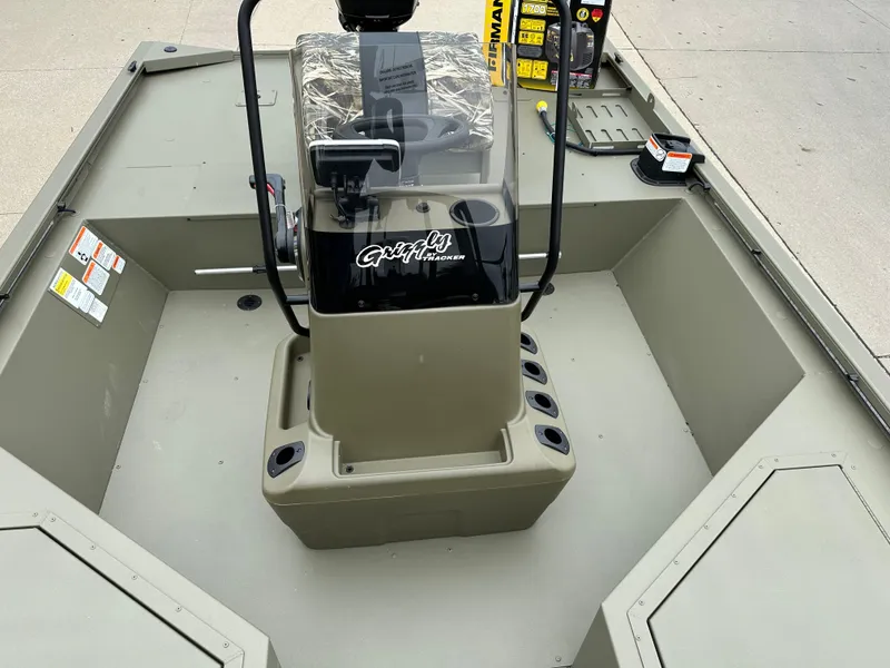 Slide: The Image of 2025 Tracker Grizzly 2072 CC Sportsman boat interior with console and storage compartments. - 10