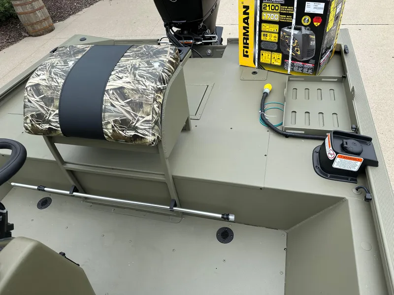 Slide: The Image of 2025 Tracker Grizzly 2072 CC Sportsman boat interior with camo seat and equipment. - 9
