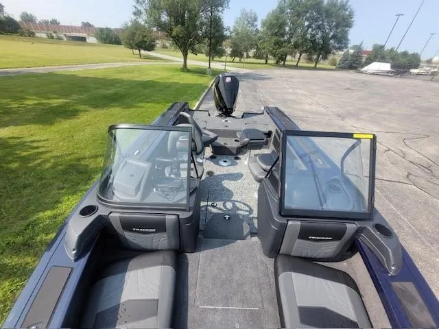 Slide: The Image of 2025 Tracker Targa V-19 Combo boat interior with seating and console, parked outdoors. - 5