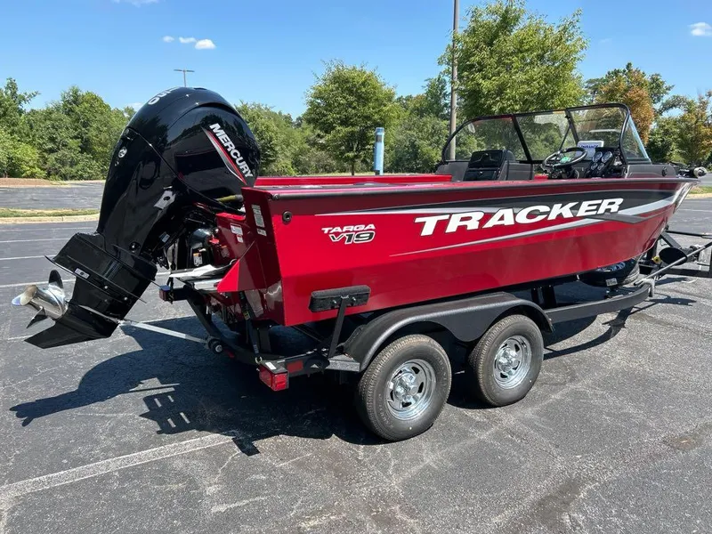 Slide: The Image of 2025 Tracker Targa V-19 Combo boat with Mercury engine, parked outdoors. - 2