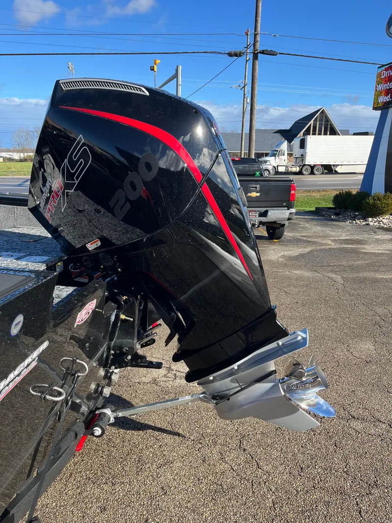 Slide: The Image of 2025 Tracker Targa V-19 Combo boat with powerful outboard motor in a parking lot. - 15