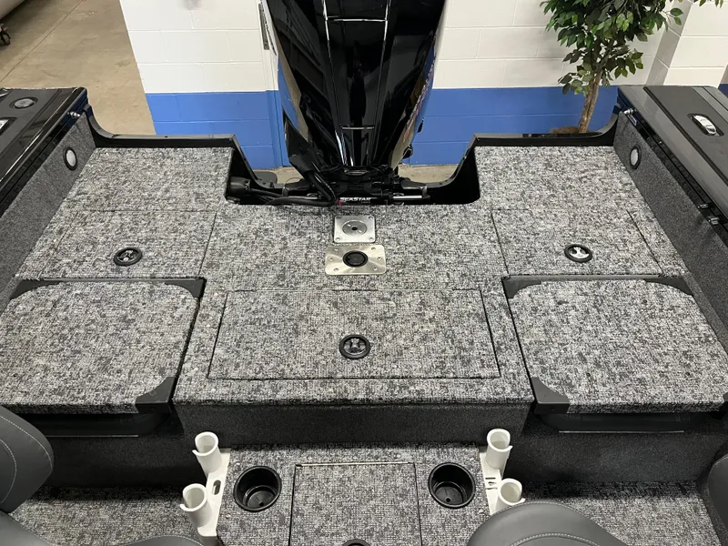Slide: The Image of 2025 Tracker Targa V-19 Combo boat interior with gray carpet and storage compartments. - 2
