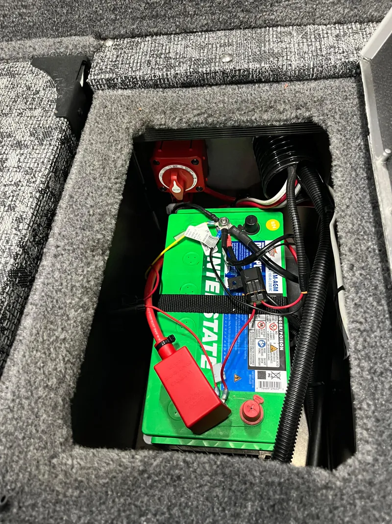 Slide: The Image of Battery compartment of 2025 Tracker Targa V-19 Combo boat, featuring a green marine battery. - 5