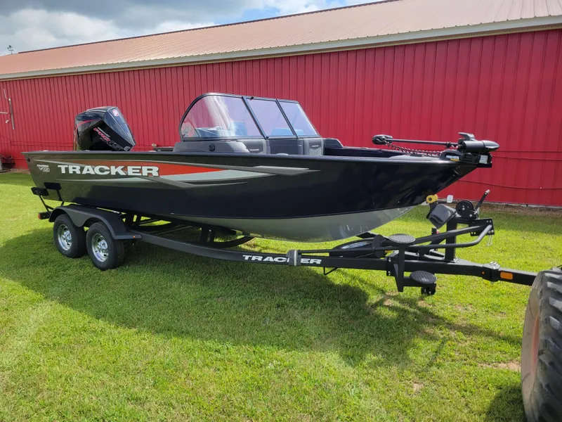 The Image of 2025 Tracker Targa V-19 WT boat on trailer, parked on grass by red building. - 0