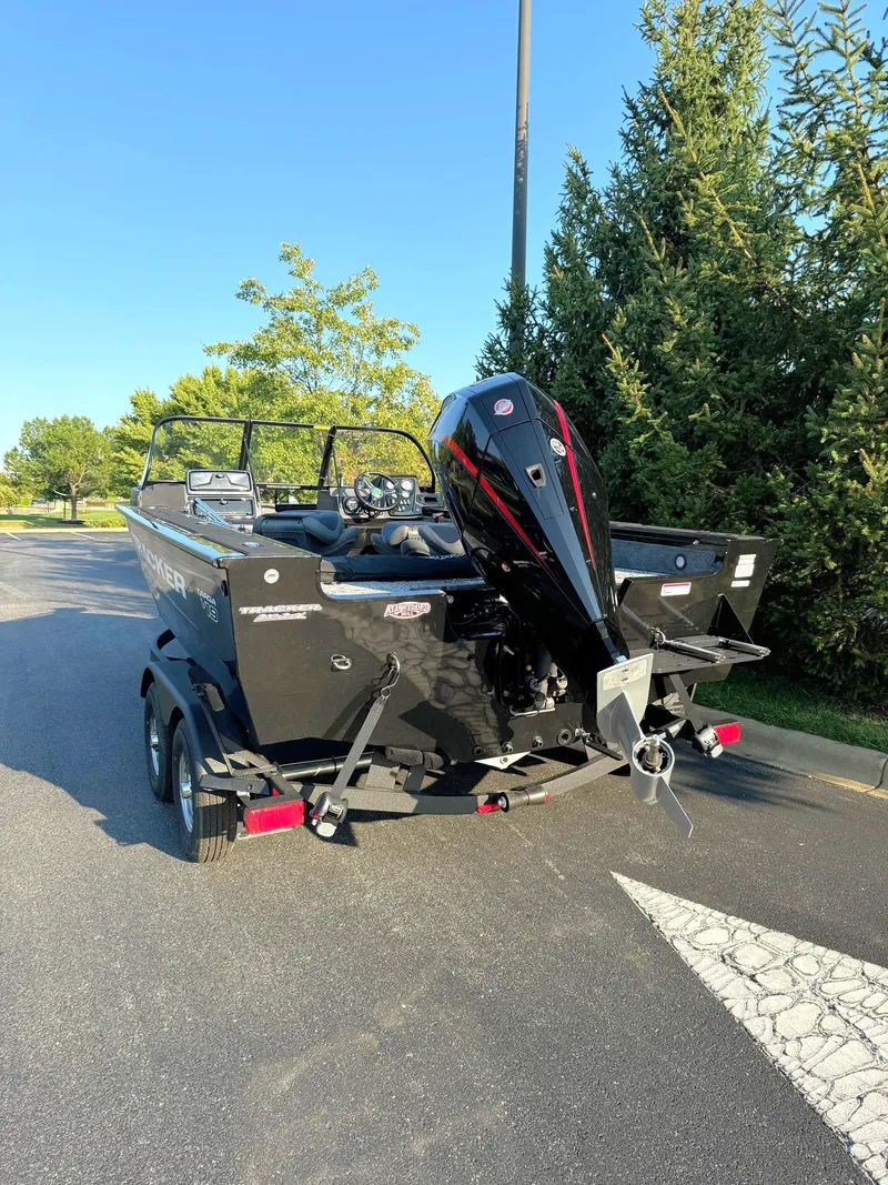 Slide: The Image of 2025 Tracker Targa V-19 Combo boat on trailer, parked on a sunny road. - 5