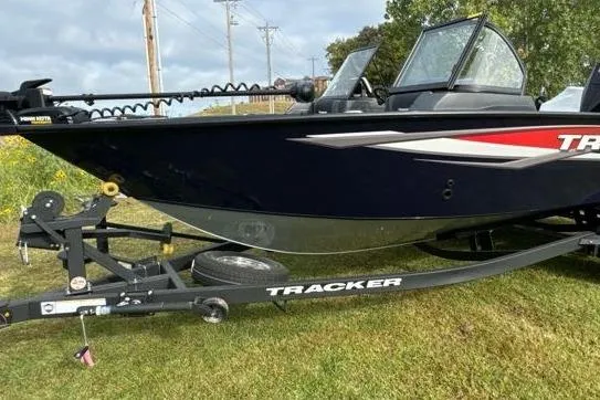 Slide: The Image of 2025 Tracker Targa V-19 WT boat on trailer, parked on grass. - 12
