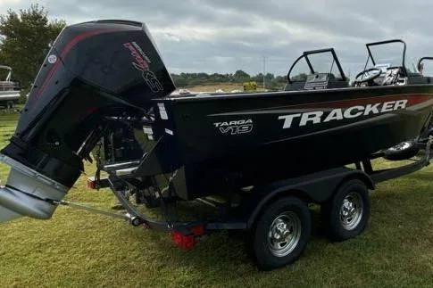 Slide: The Image of 2025 Tracker Targa V-19 WT boat on trailer, parked on grass under cloudy sky. - 15
