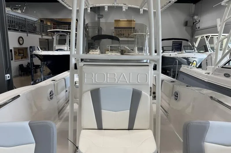 Slide: The Image of 2025 Robalo R 200 CC boat interior with seating and console in showroom. - 7