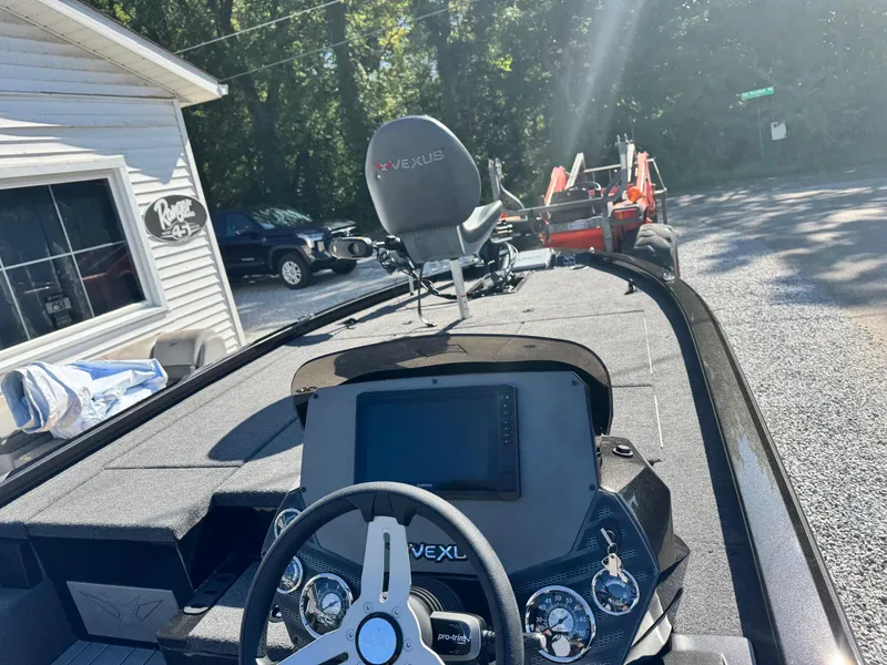 Slide: The Image of 2025 Vexus AVX2080 boat interior with steering wheel and dashboard, parked outdoors. - 6