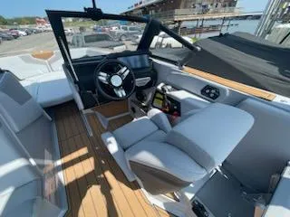 Slide: The Image of 2024 Nautique GS24 boat interior with modern dashboard and seating. - 13